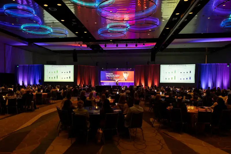 A wide view of the illuminated forum stage and audience seating.