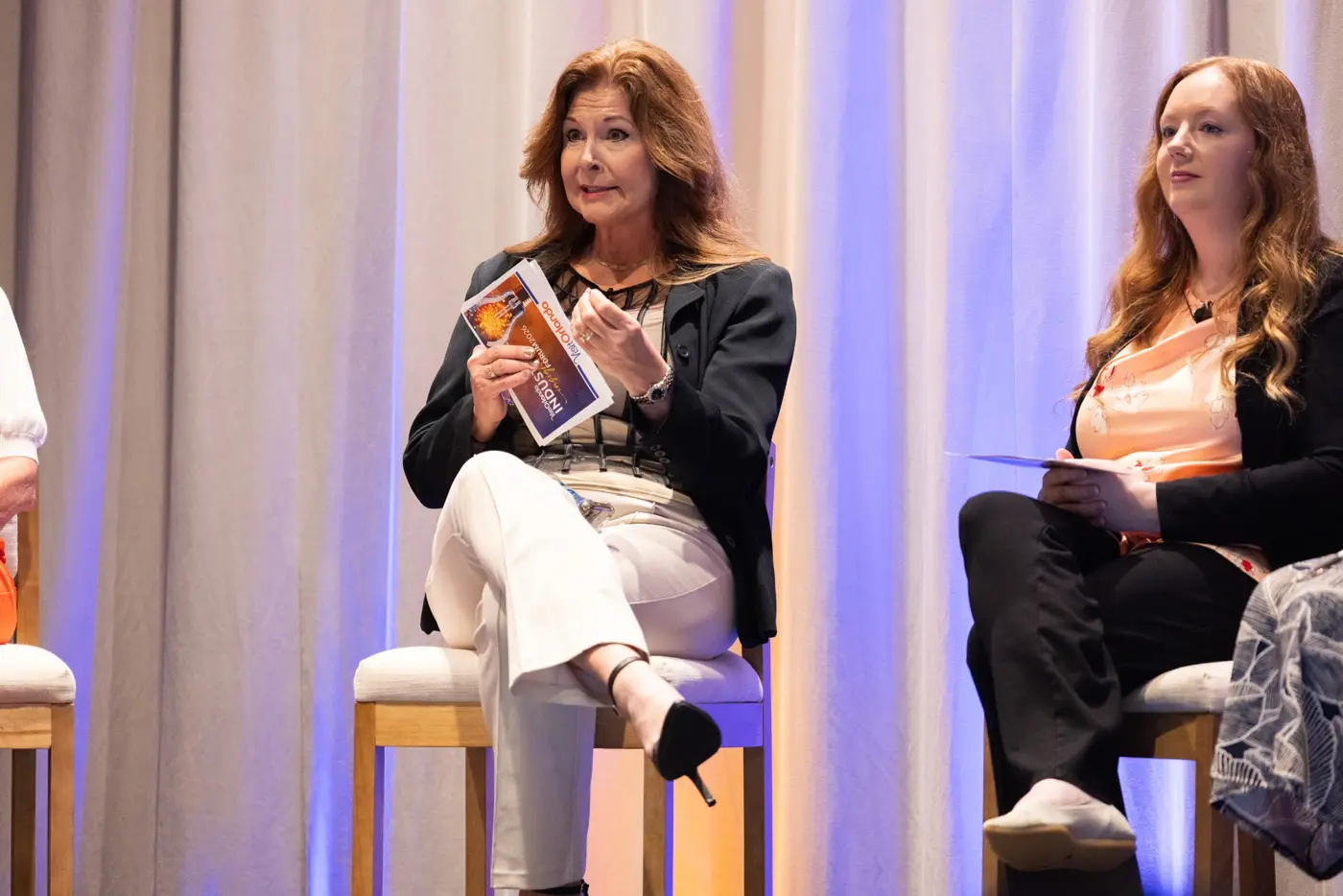 Two seated panelists listen and speak during a forum discussion.