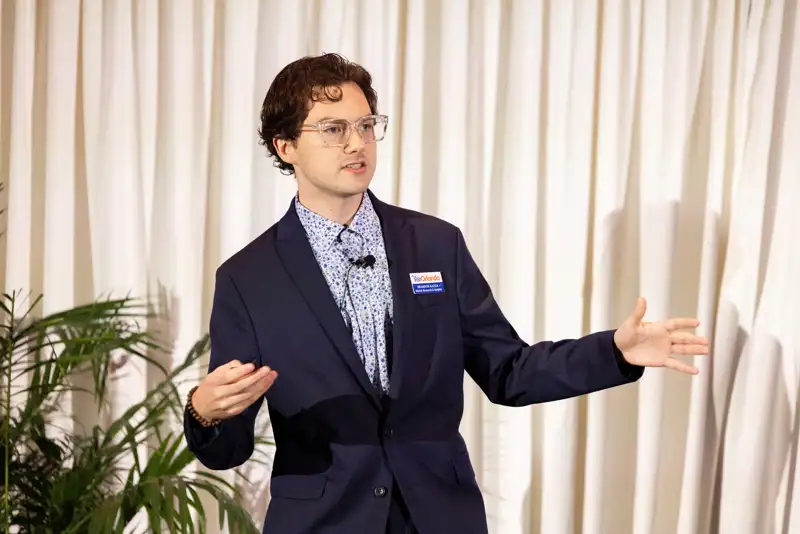 A standing attendee holds a microphone during the program.