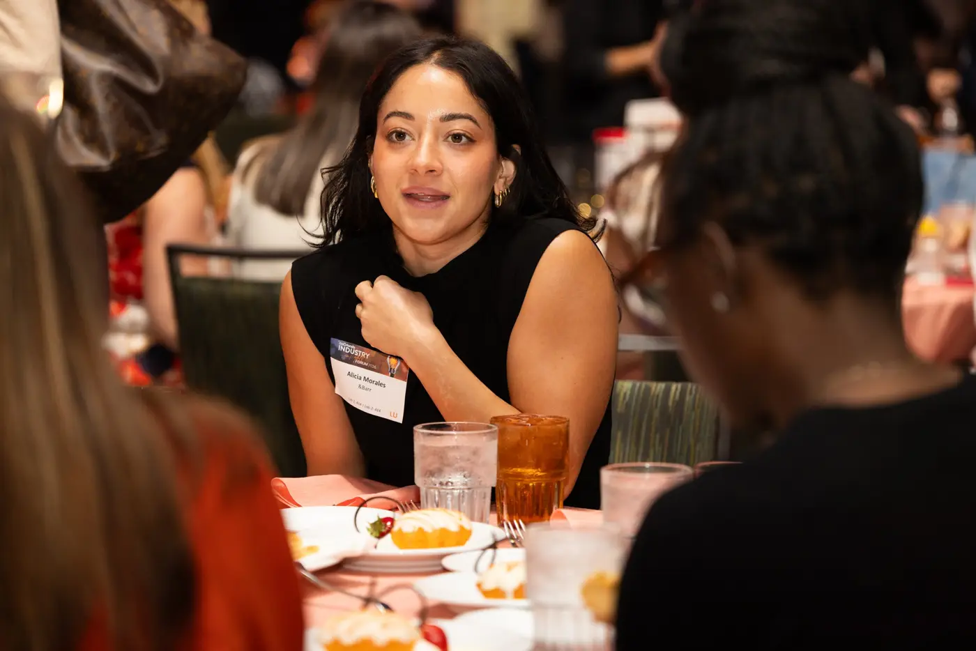 An attendee speaks with another guest across a round table.