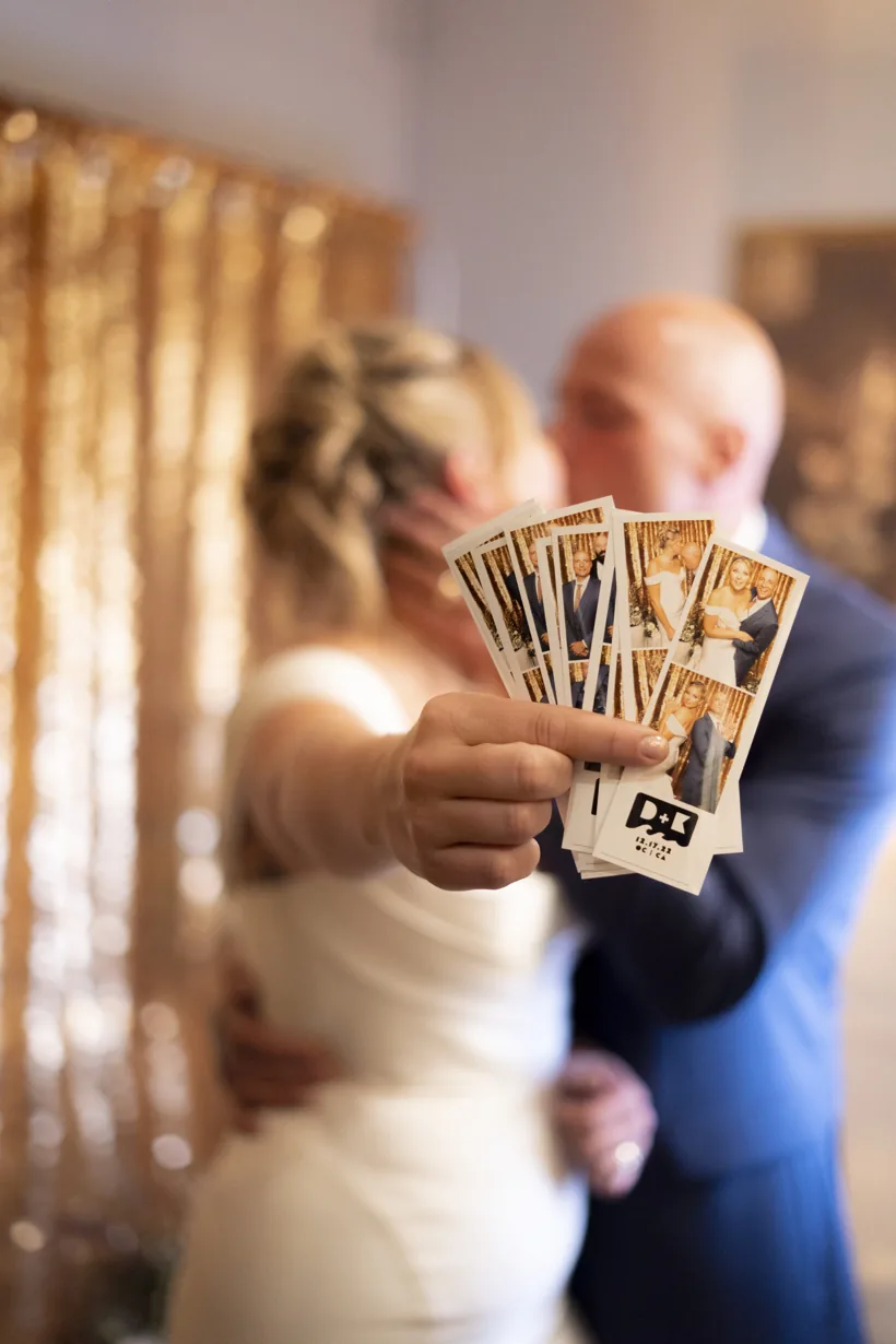 Bride and groom holding their wedding photo booth prints at an Orlando wedding