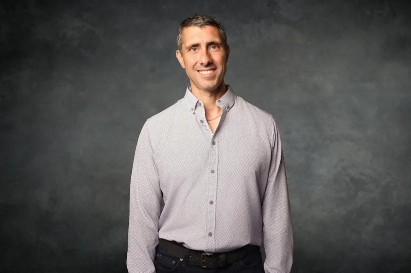 Executive headshot on a textured gray studio backdrop