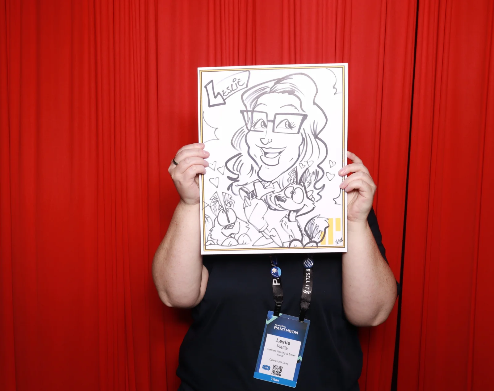 Sweet Shoppe Social guest holding a caricature against the red photo booth background