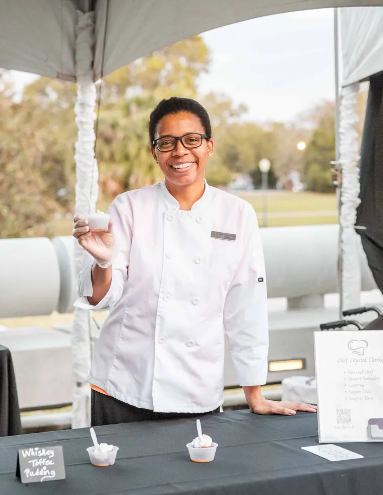 Event photography of a catering team member at a branded tasting station at a corporate event