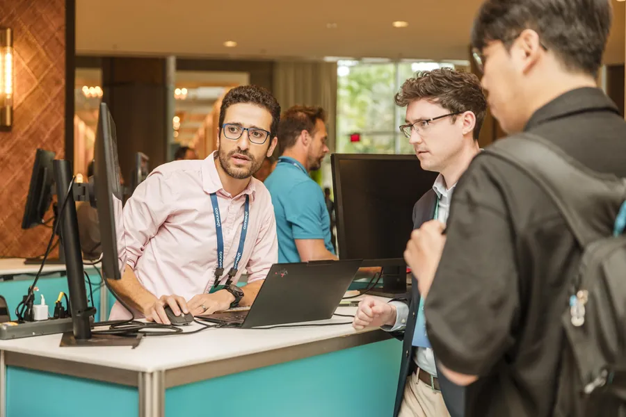 Trade show photography of attendees at a product demo station on a conference expo floor