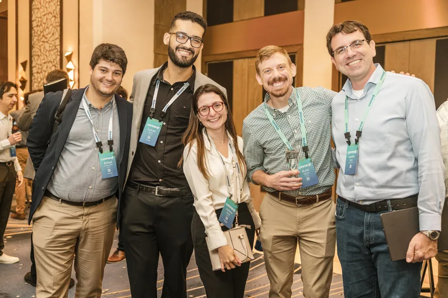 Corporate group photography of conference attendees posing together with event lanyards