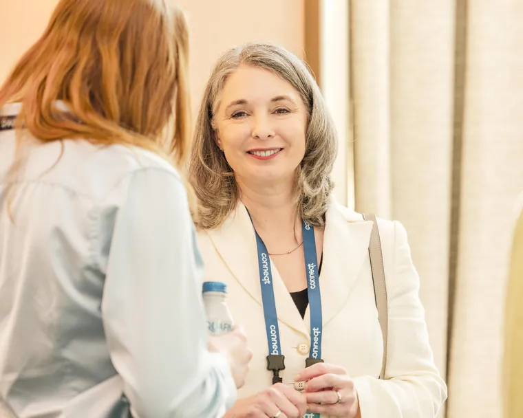 Networking photography of two attendees in conversation at a corporate conference reception