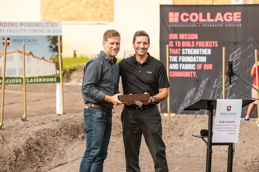VIP event photography of executives shaking hands in front of branded event signage