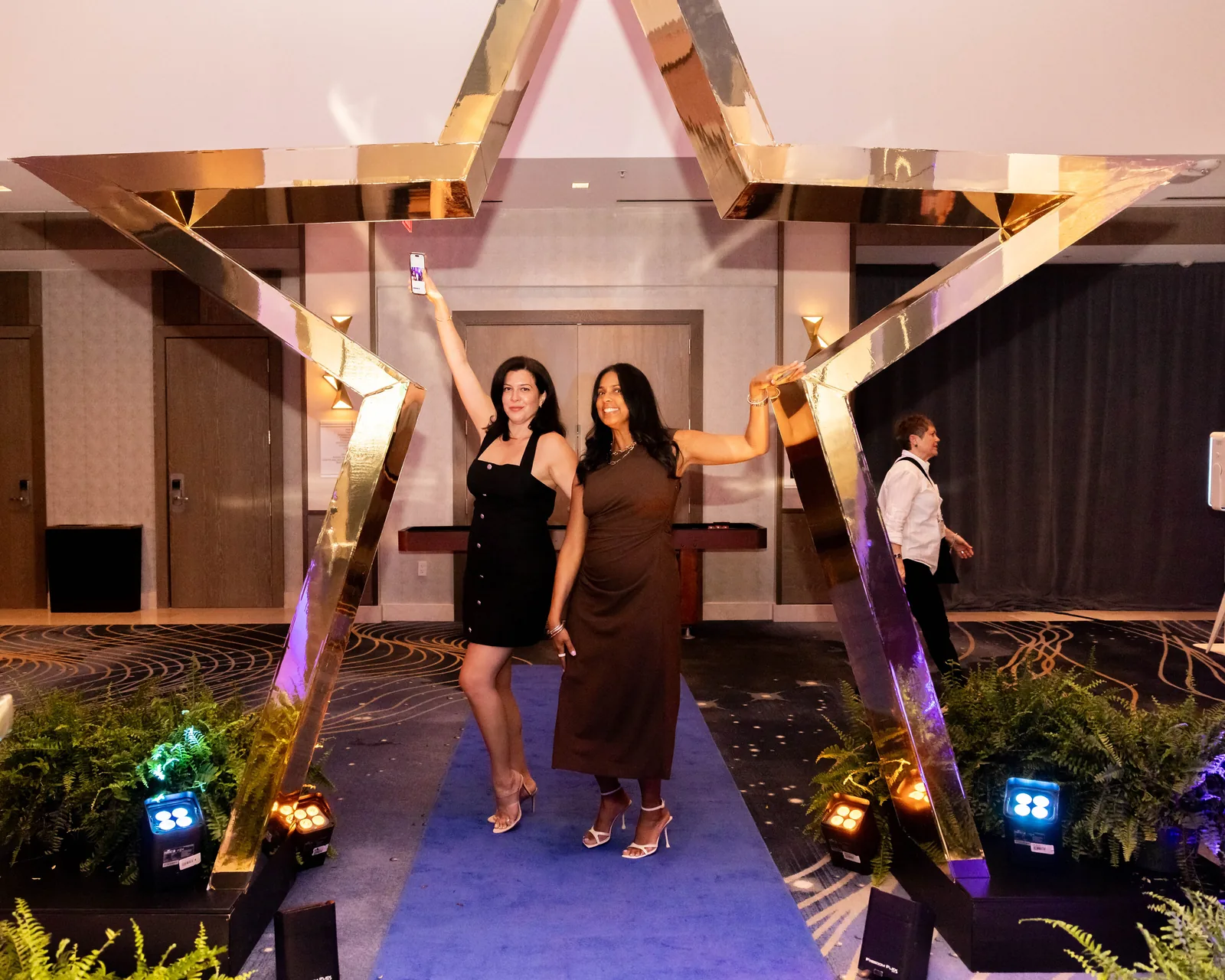 Guests posing at an illuminated gold star brand activation at a corporate gala in Orlando
