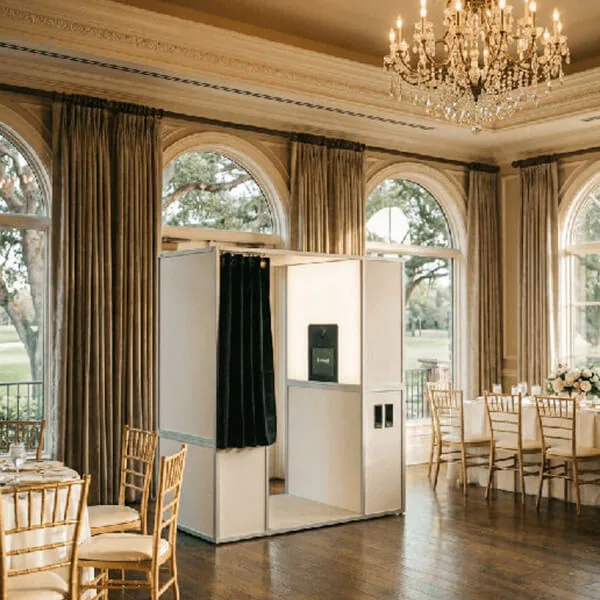 White enclosed Vintage Sit-In Photo Booth set up in an elegant Orlando wedding ballroom